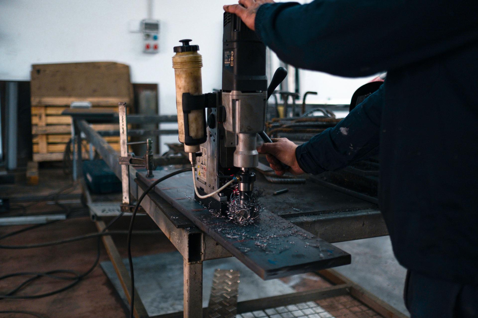 Industrial worker operating a magnetic drill press