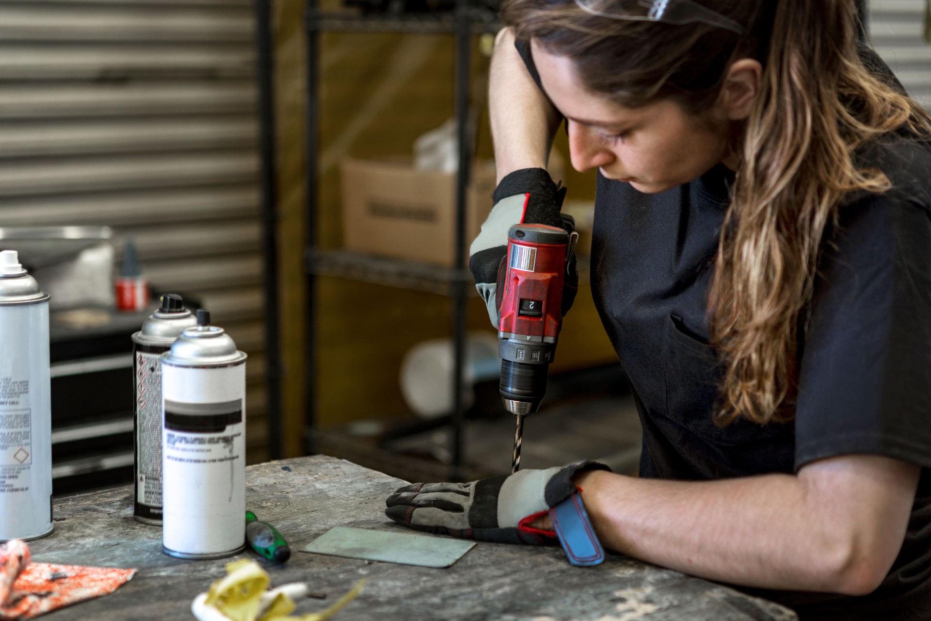 Female mechanic drilling into metal